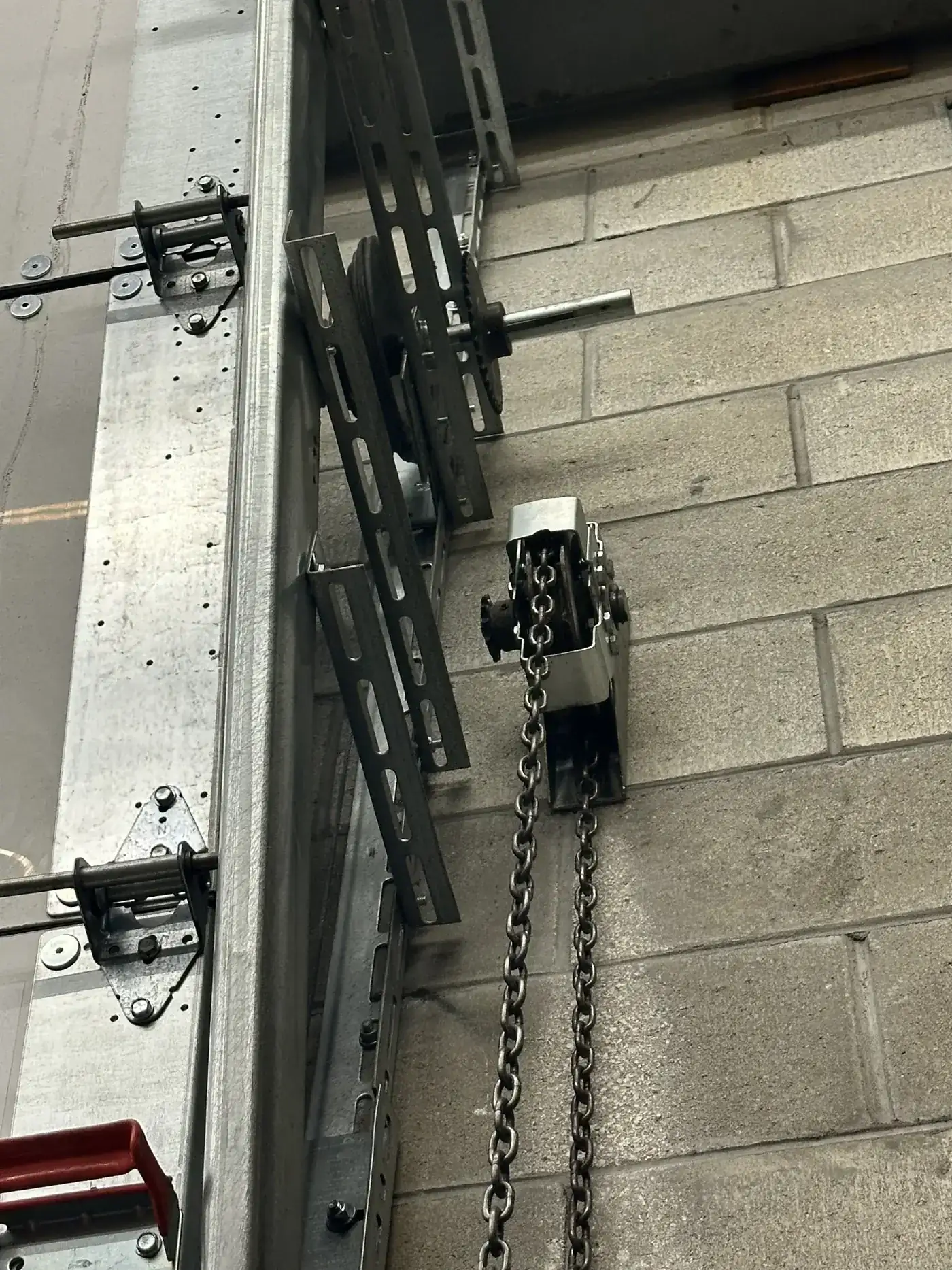 Chain hoist operator and reduction gear on a commercial rolling door