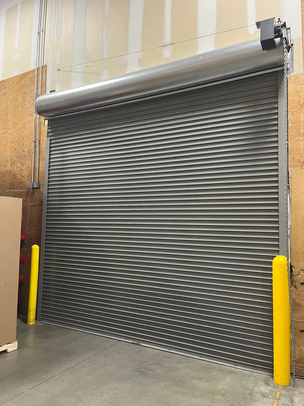 Rolling steel door and protective bollards installed at a commercial site