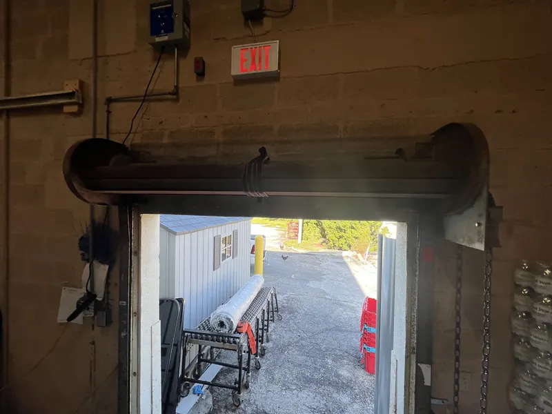 Rolling steel door hood and coil above an open bay