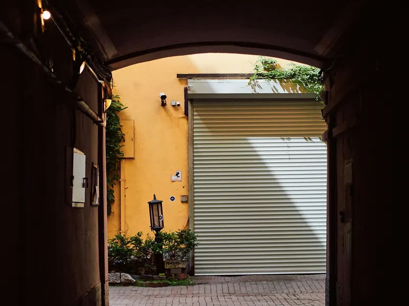 White rolling steel door at a courtyard entrance
