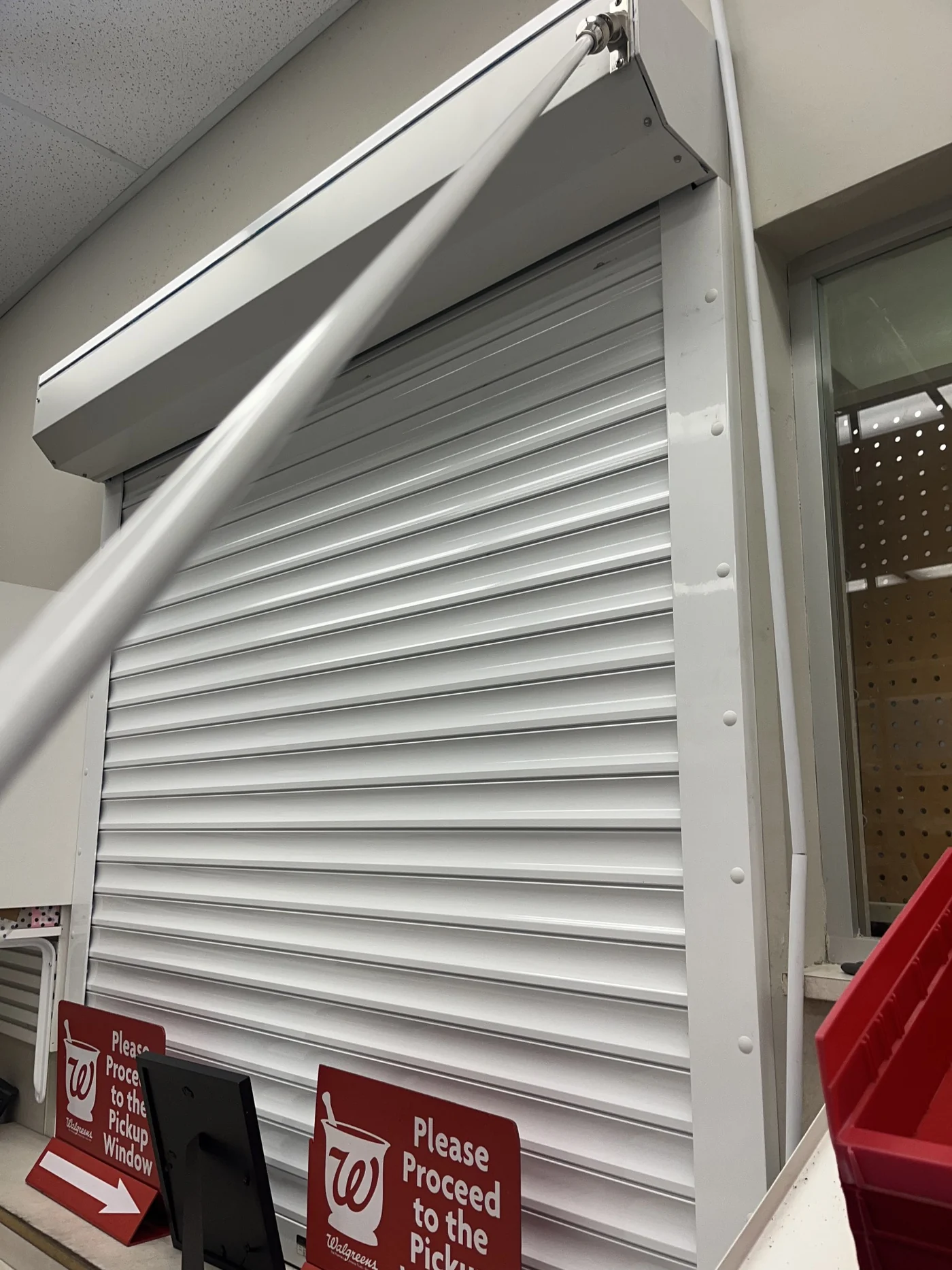 White rolling steel door closed across a retail stockroom entrance, serviced by CMC Door Service