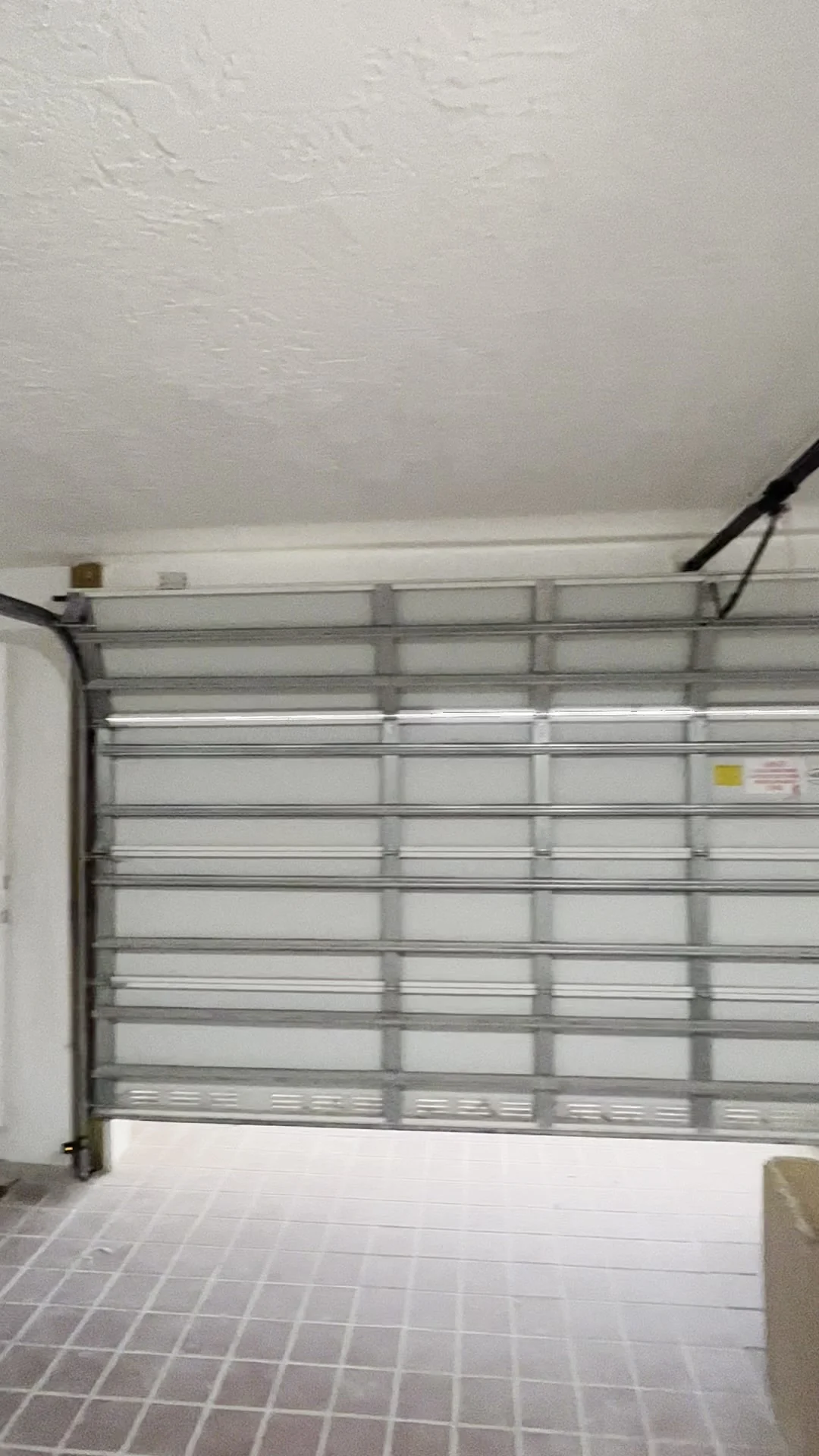 Newly fitted white sectional garage door seen from inside the garage