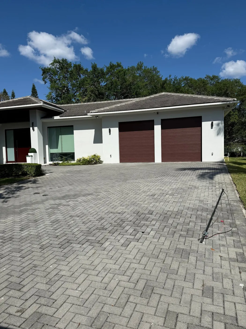 Three-car garage doors installed on a modern South Florida home