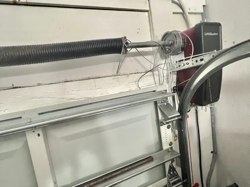 New torsion spring and opener rail installed above a garage door