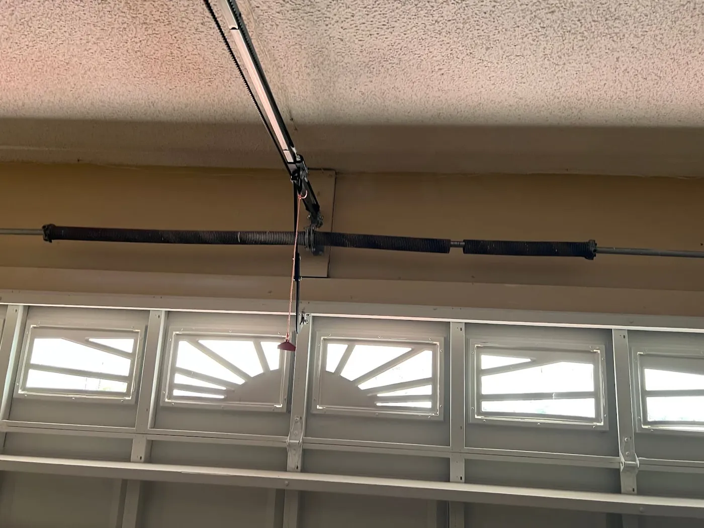 Torsion spring and shaft above a garage door
