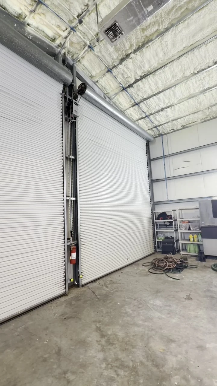 White rolling steel door in a warehouse bay, fitted by CMC Door Service
