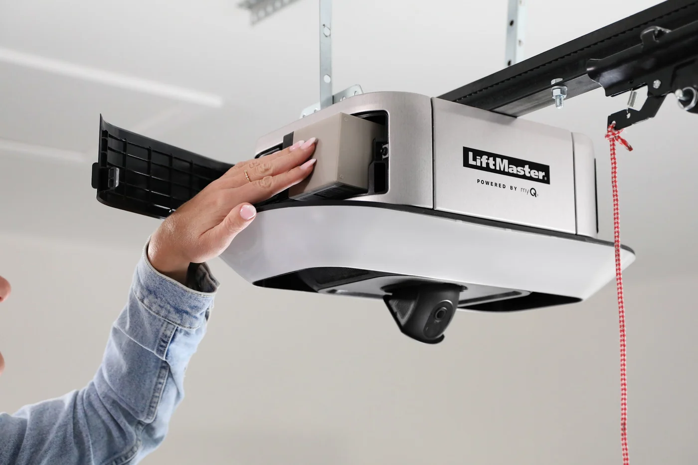Hand opening the battery backup compartment on a LiftMaster belt drive opener