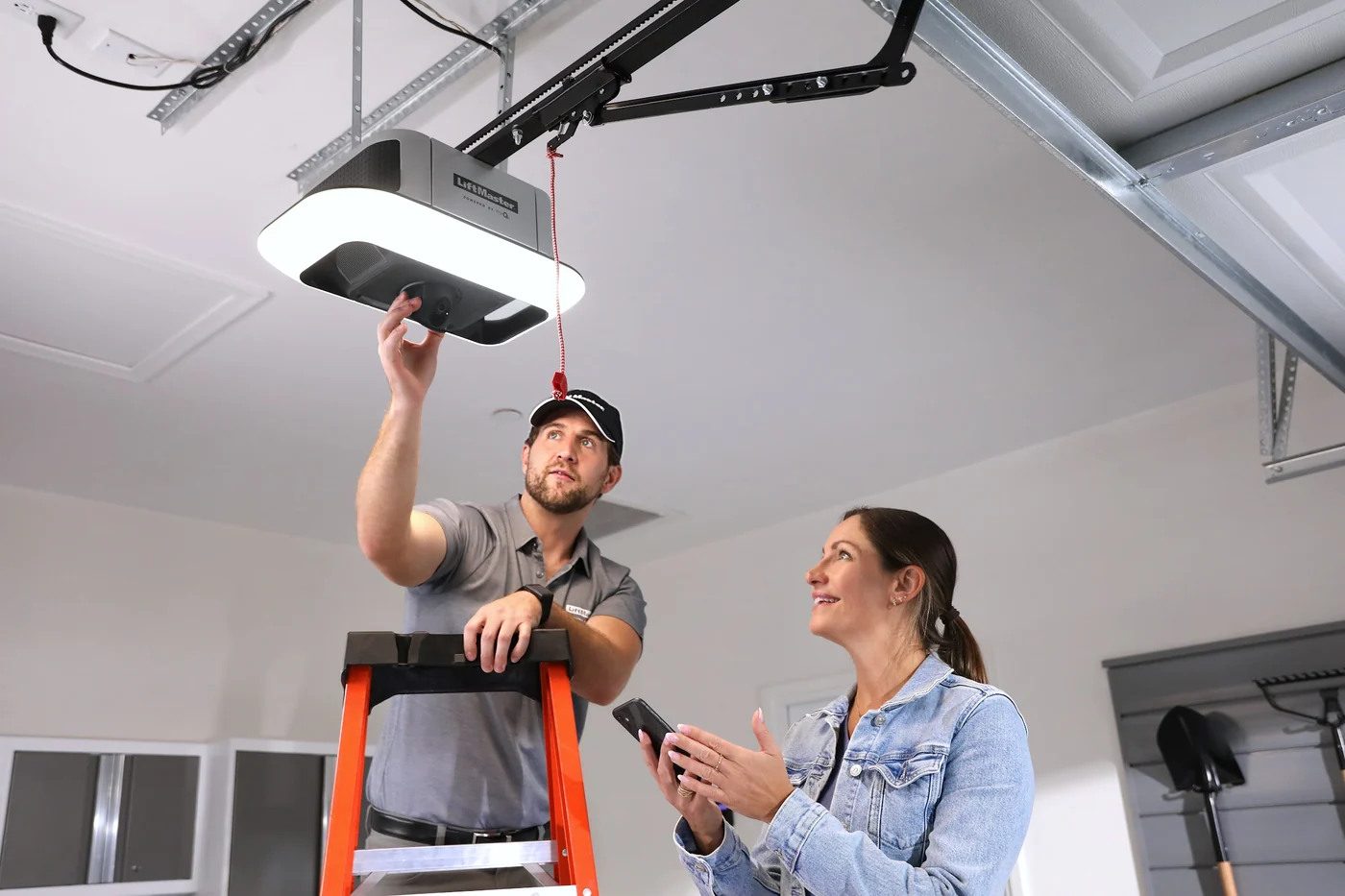 Technician showing a homeowner the light and safety reverse on a newly fitted LiftMaster opener