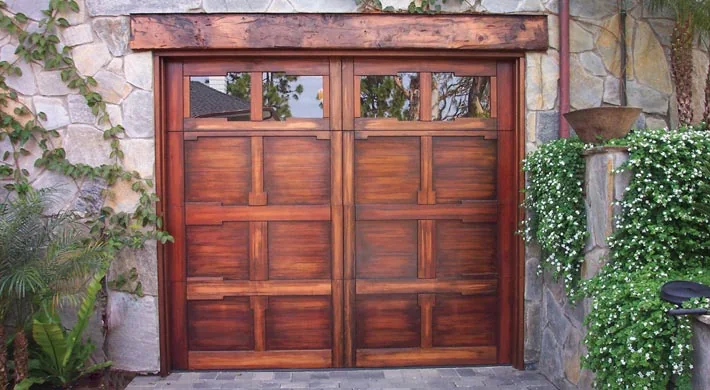 Three tan carriage house garage doors with window inserts
