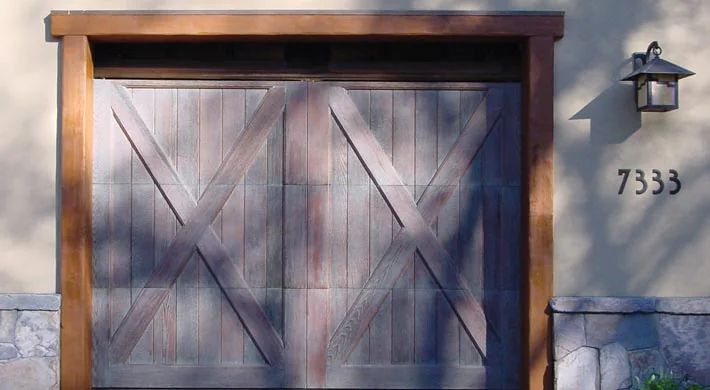 Wood carriage doors on a tile roof Mediterranean home