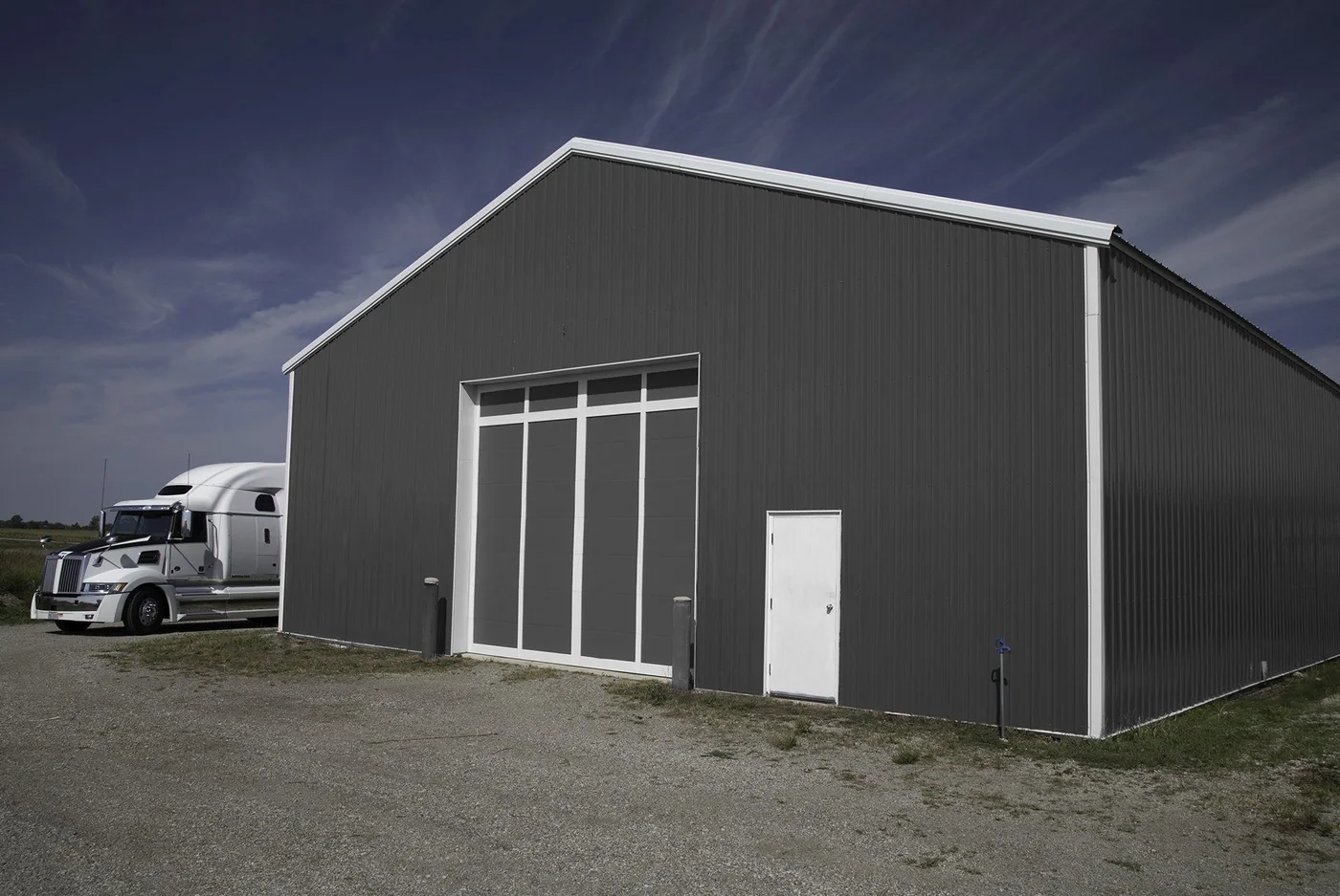 A dark clad commercial building with a wide sectional door