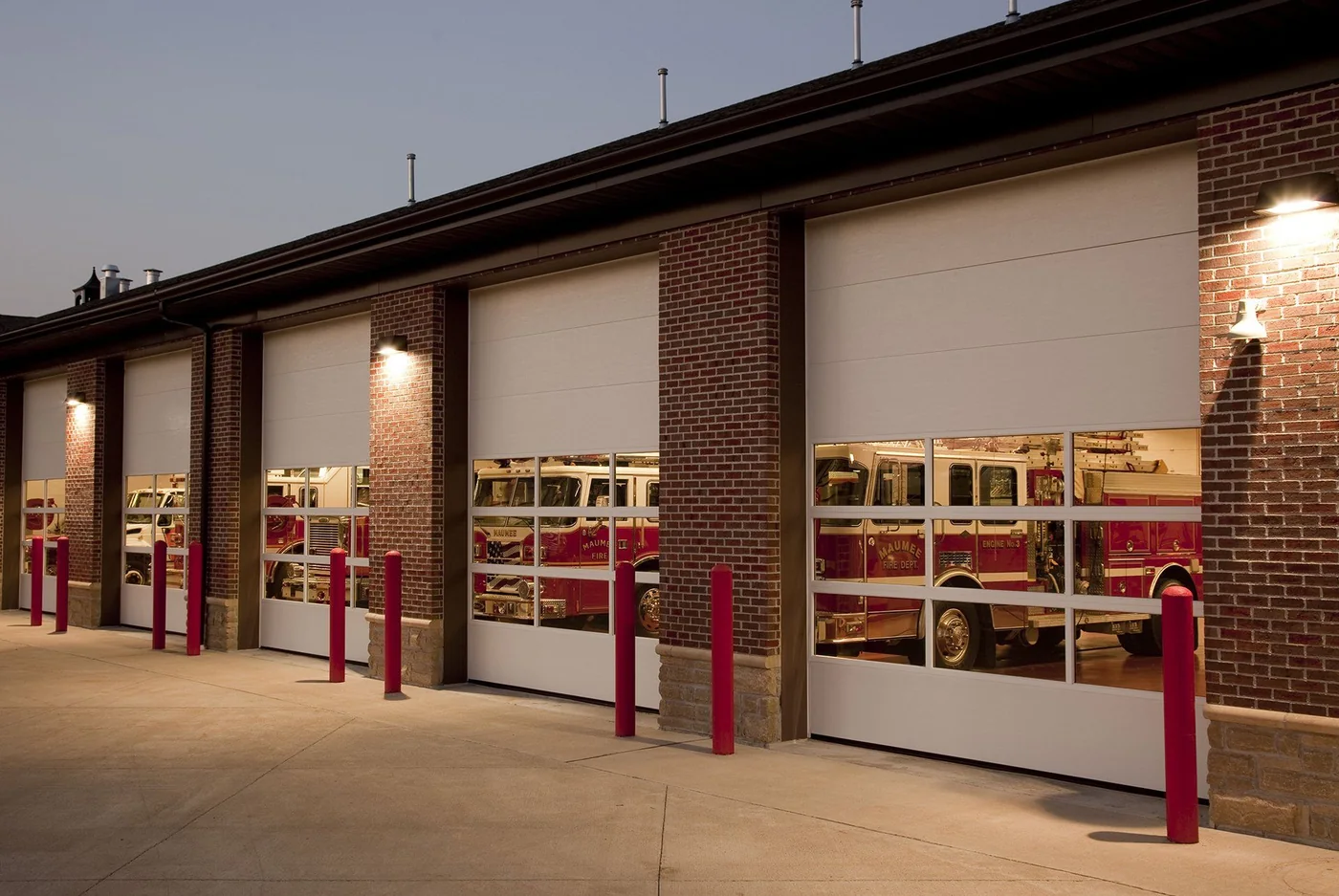 Red framed fire station bay doors with apparatus behind