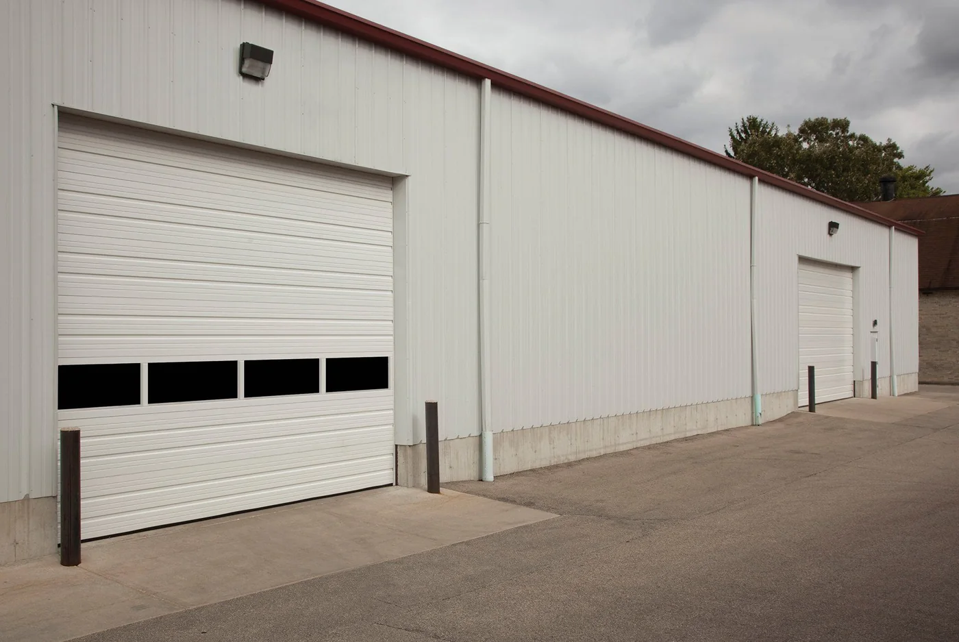 A white commercial sectional door on a warehouse elevation