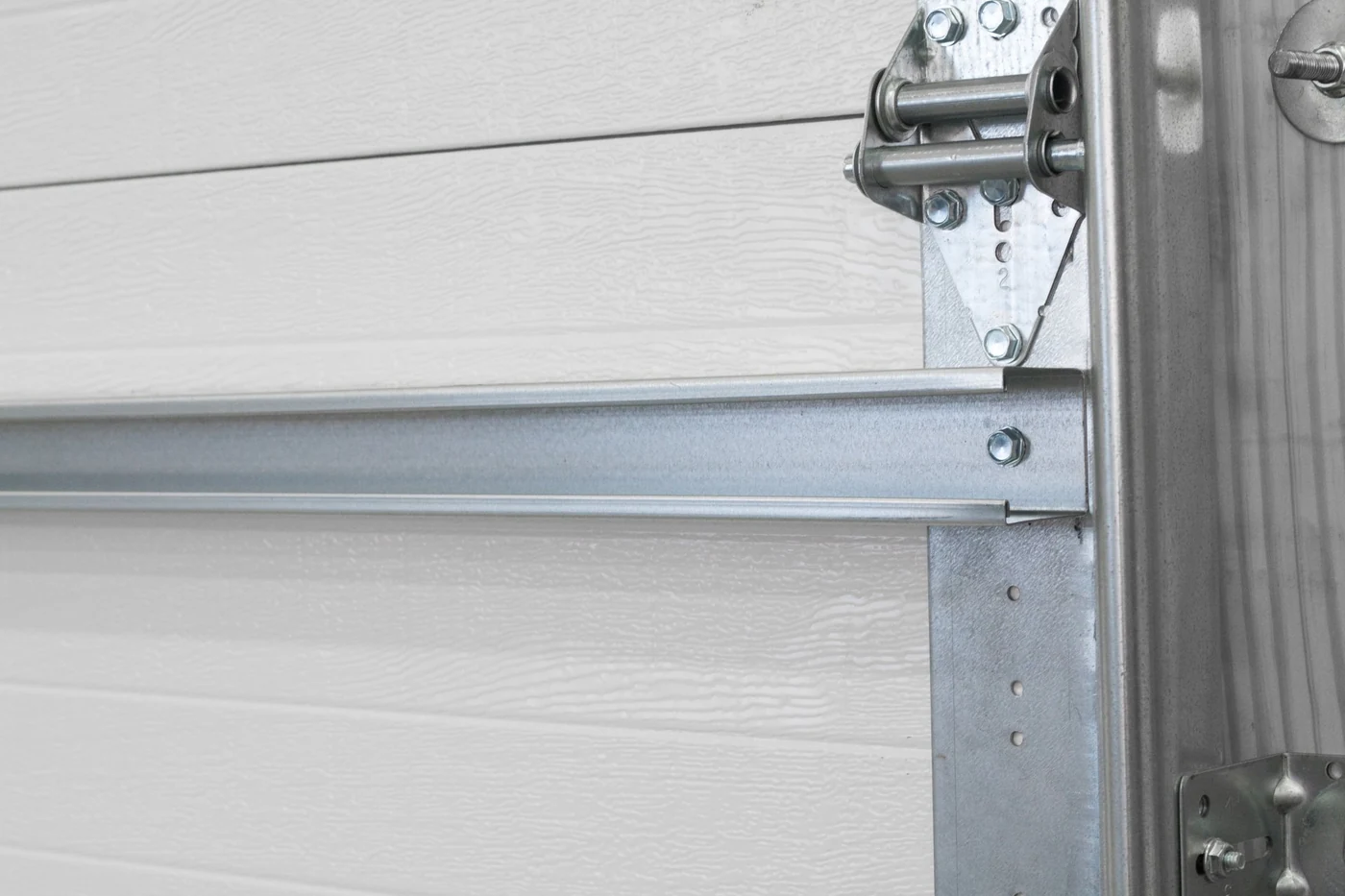 Close-up of a reinforcement strut, hinge and roller bracket on a sectional garage door