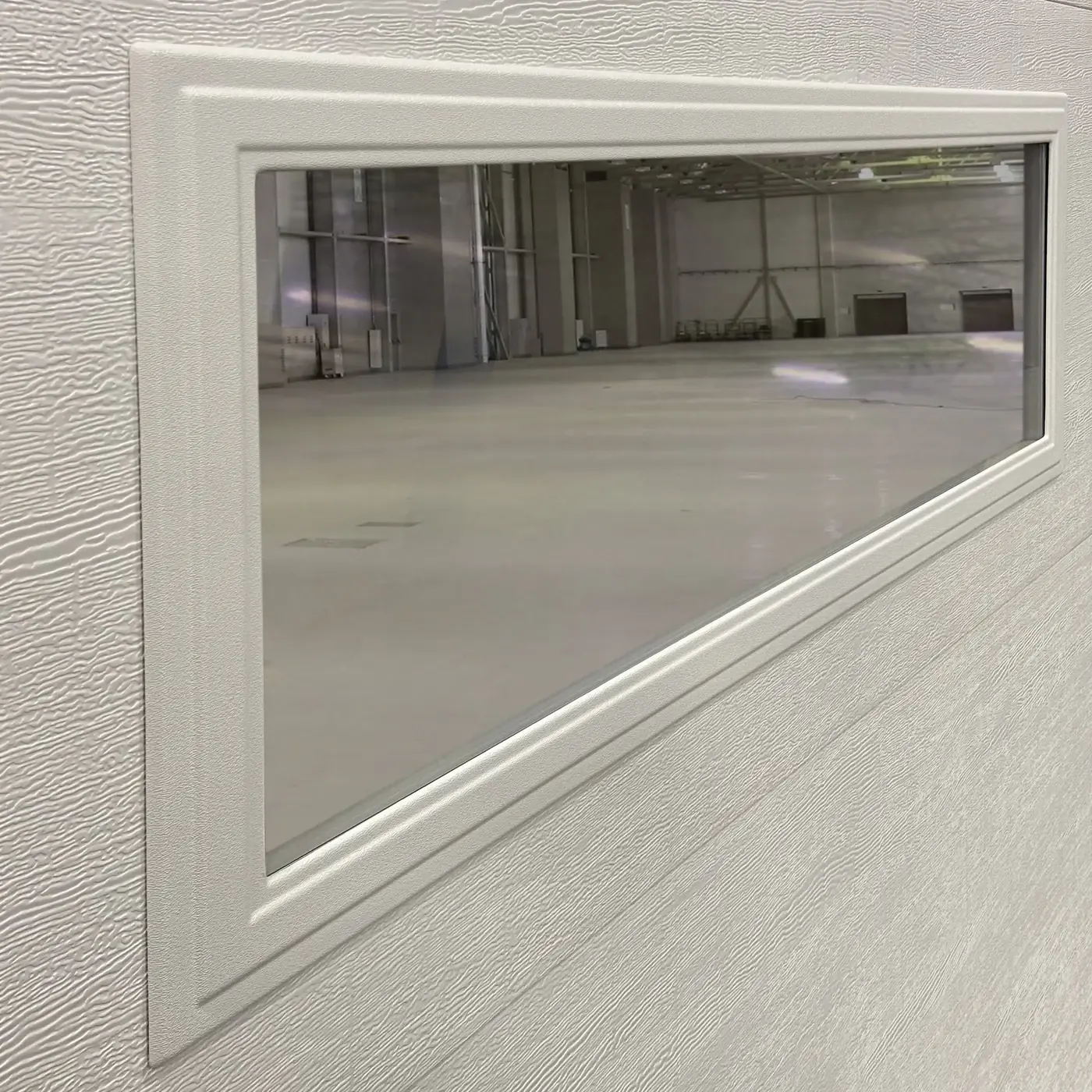 Close-up of a glazed window insert framed into a garage door section