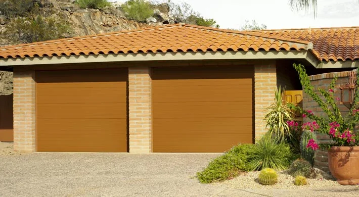 A columned Mediterranean entry with a white garage door
