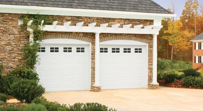 A coral coloured modern Florida home with a light full view garage door