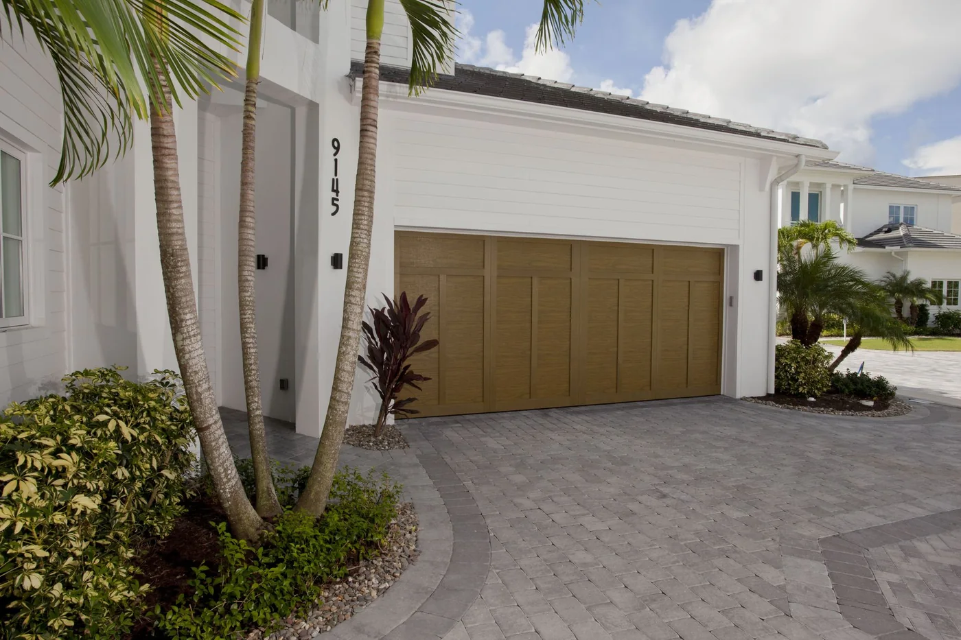 A teal and white modern Florida building with a full view glass door