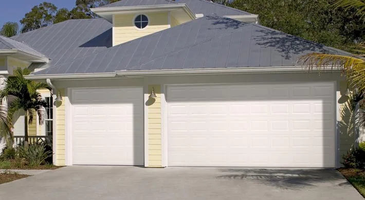 A terracotta tile roof home with a tan garage door