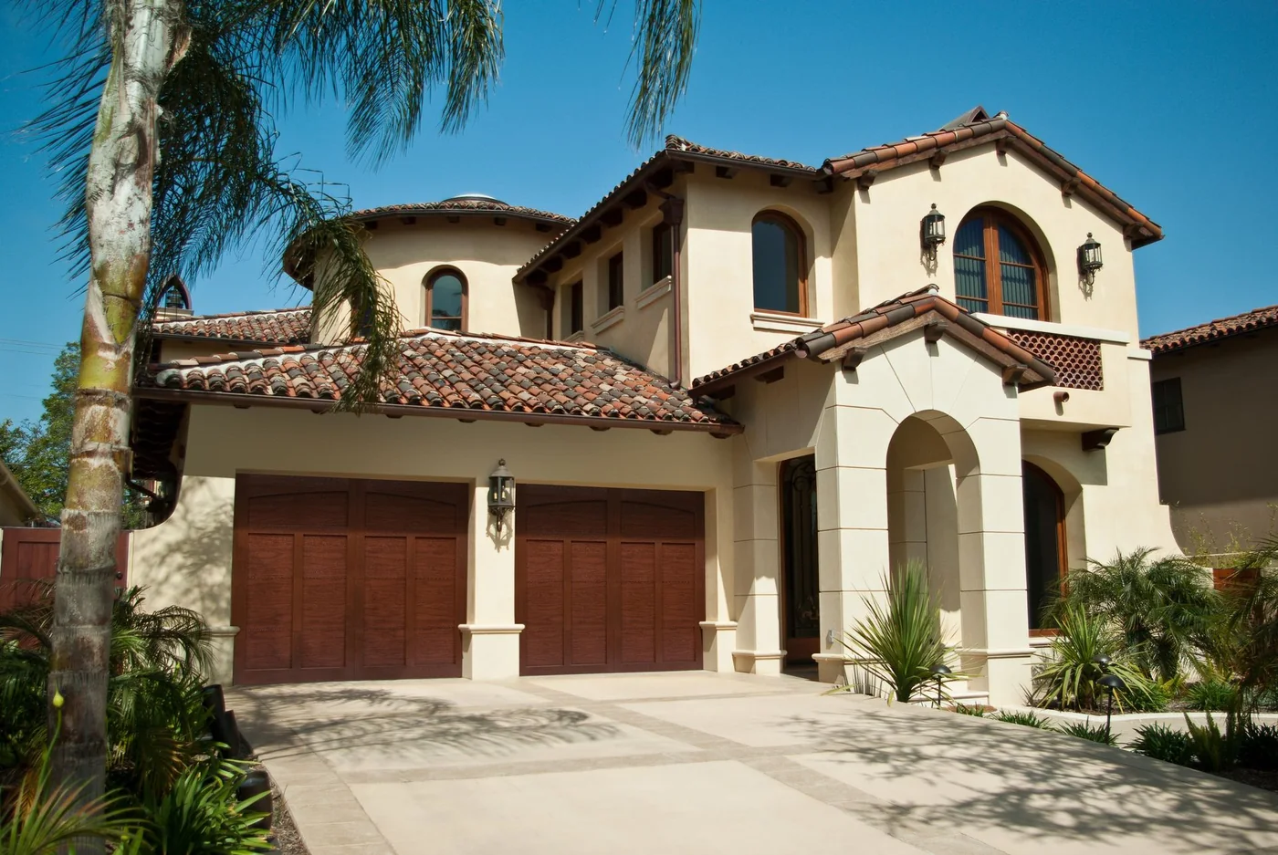 A Spanish tile roof home with a wood grain garage door