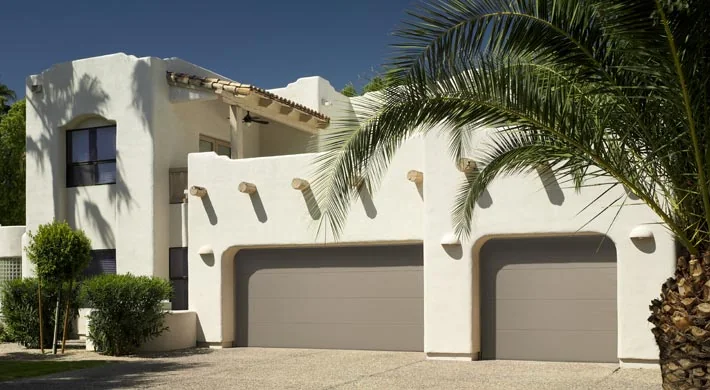 Two white garage doors on a white stucco Florida home