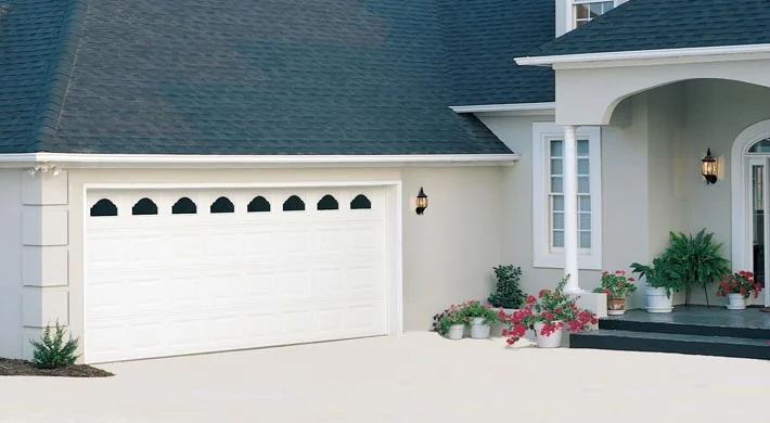 A white garage door with a row of arched window inserts