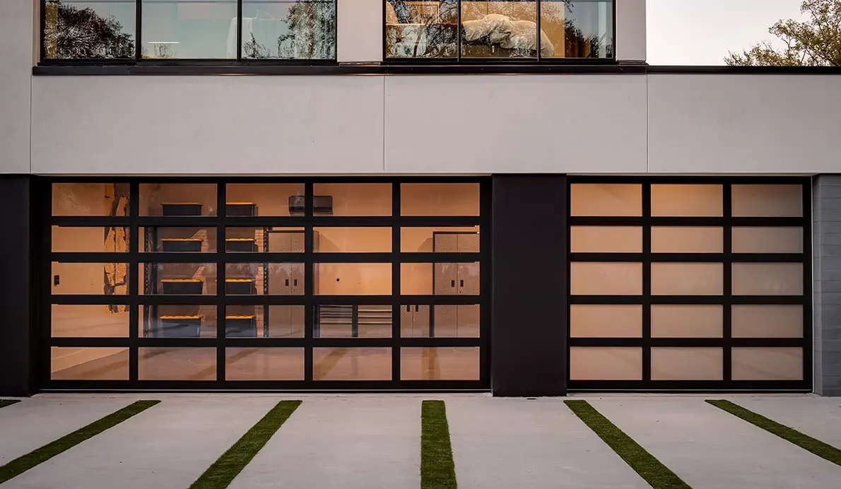 A black framed full view glass garage door on a modern house