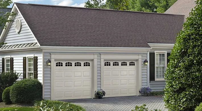 A dark flush panel garage door on a low modern house
