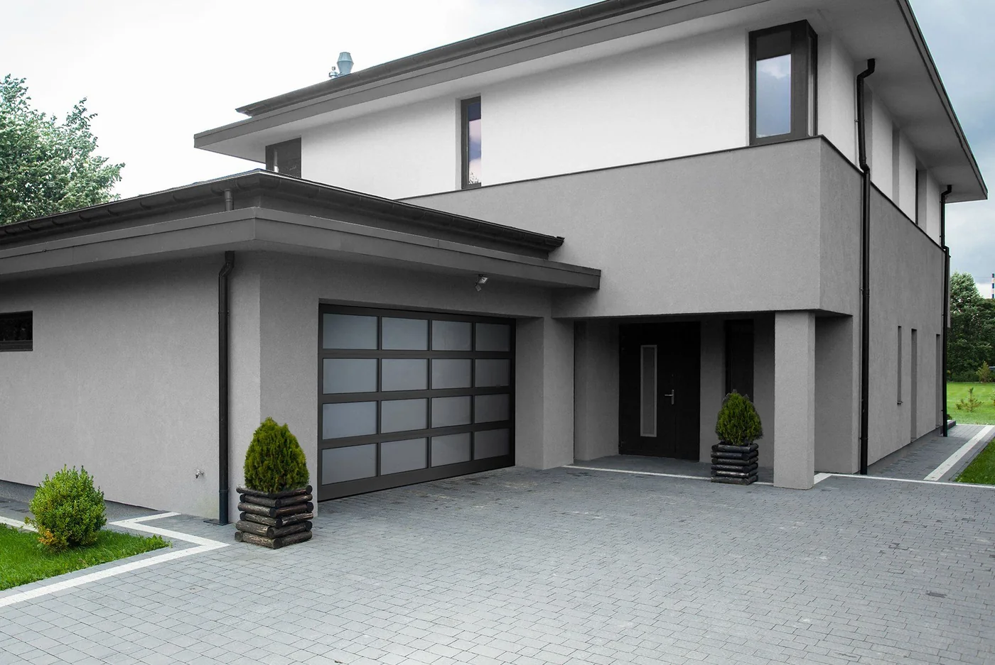 A modern home with a full height glass entry beside the garage