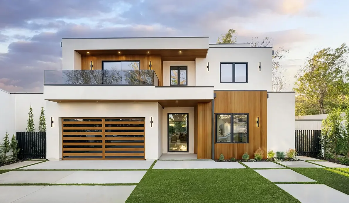A modern red clad home with a black slatted garage door