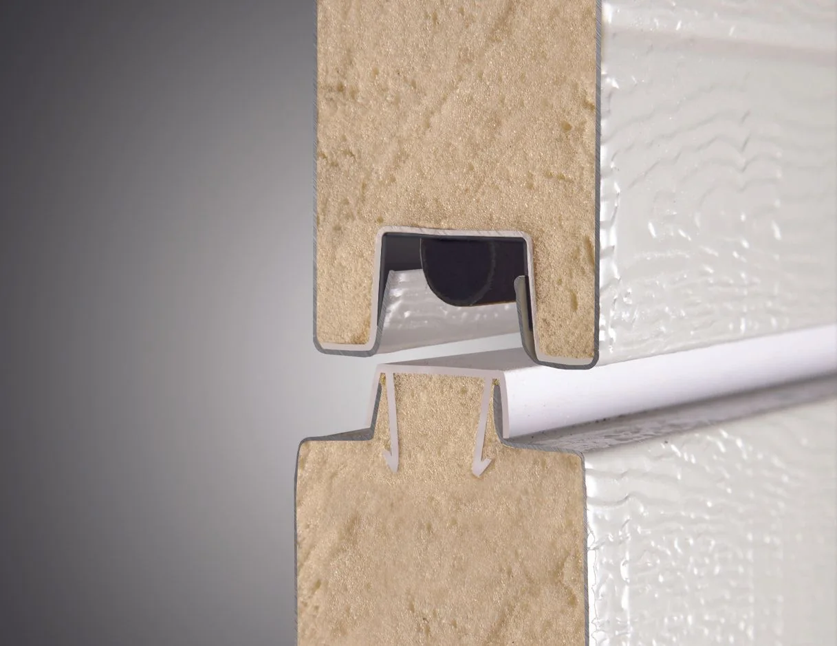 A cutaway of a garage door bottom seal seated against the floor