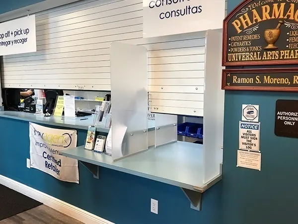 Counter shutters rolled up over a pharmacy drop off and pick up counter