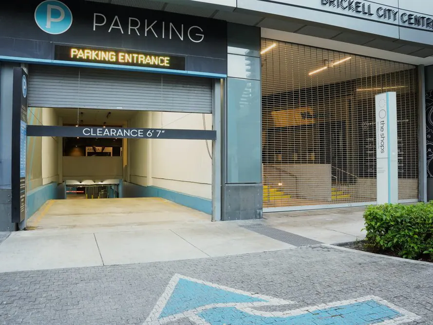 Rejas enrollables en la entrada de un estacionamiento junto al letrero de altura libre