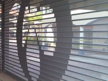A perforated rolling door with a printed graphic showing through the holes