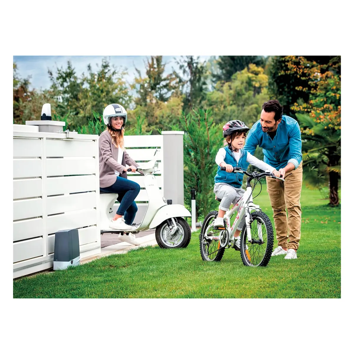 A family on bikes in front of a white slide gate, CAME BXV lifestyle photo