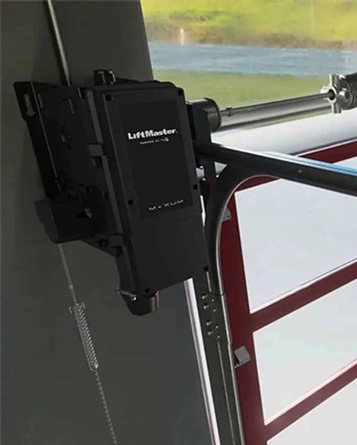 LiftMaster Maxum RJDC jackshaft operator mounted on the wall beside a commercial door shaft