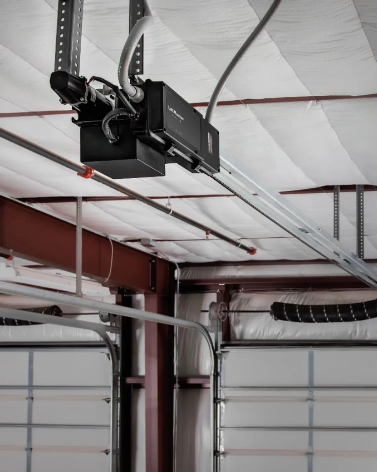 LiftMaster Maxum TDC trolley operator installed on a warehouse ceiling above a sectional door